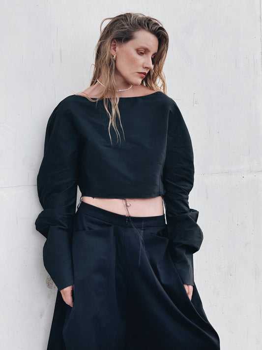Front view of a black silk taffeta cropped top with voluminous long sleeves and raw-edge hem