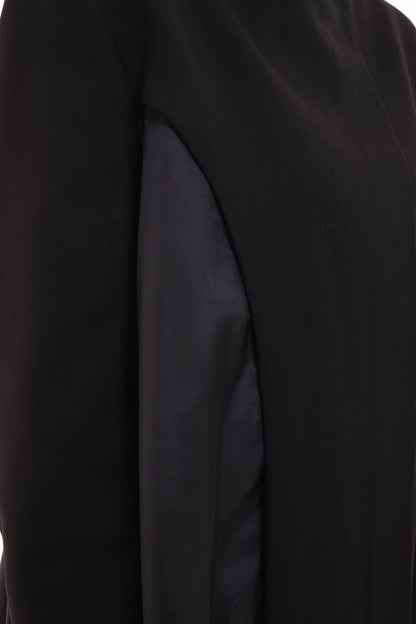 Closeup of oversized black stand-collar blazer showing asymmetric cutout