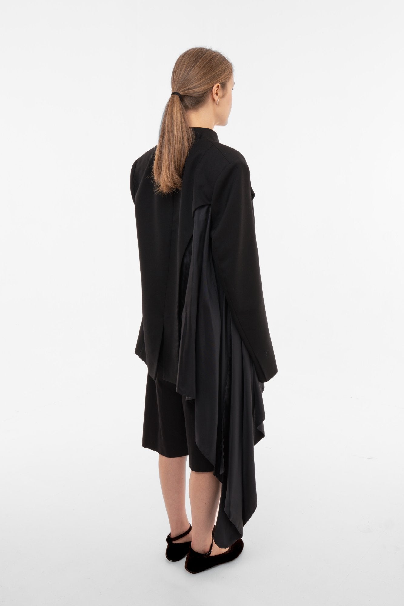 Black oversized stand-collar blazer back view with dramatic asymmetric satin draping and flowing lining - Sazha Barcelona