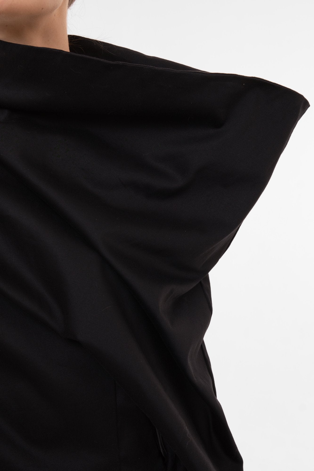 Black fabric draped over a person on a white background