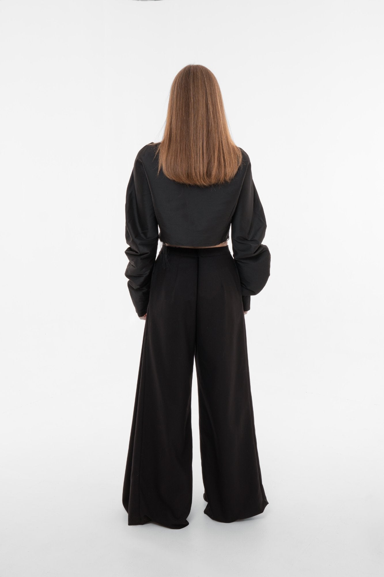 Back view of high-waist wide-leg trousers with clean lines and structured heavyweight fabric