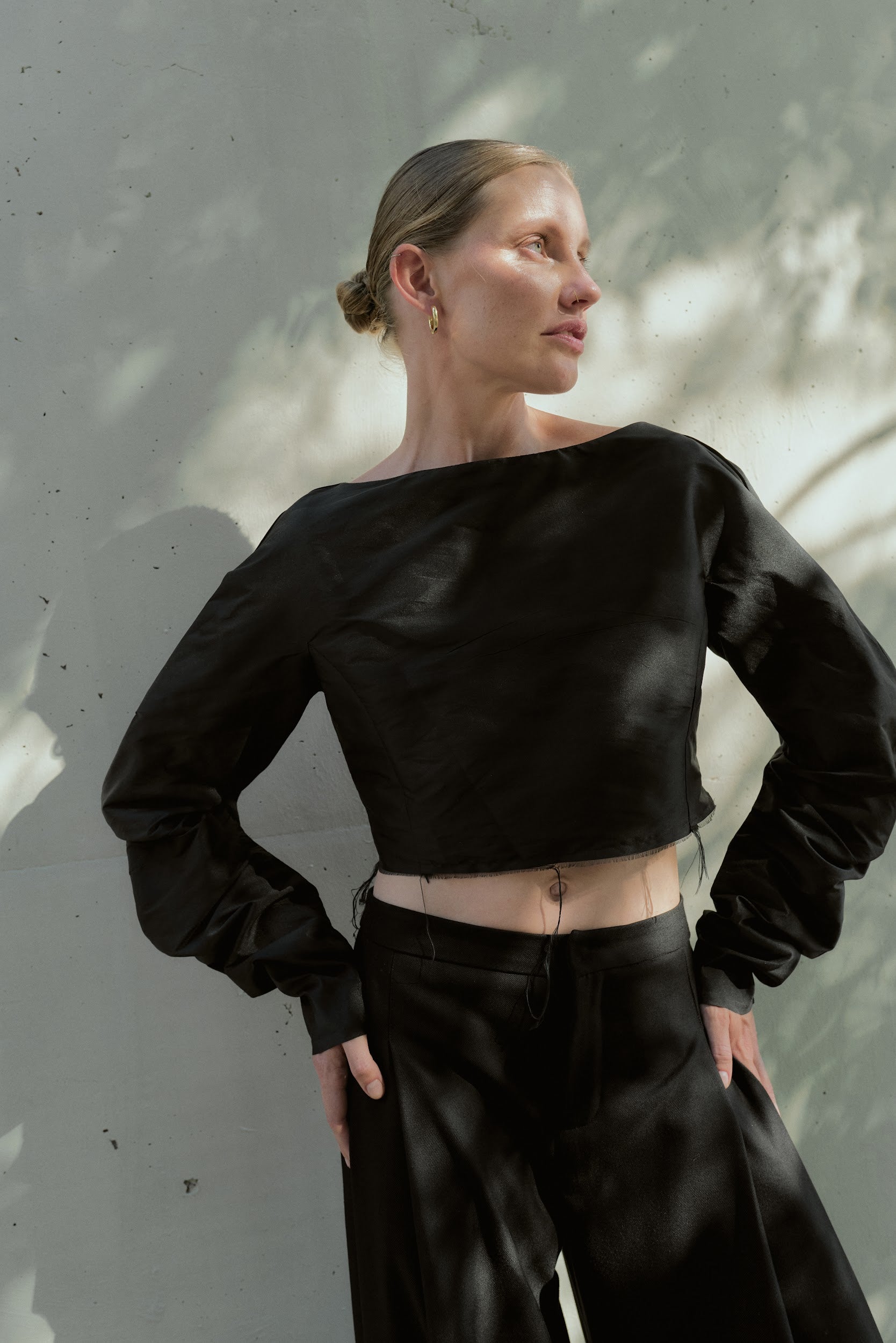 Front view of a boxy black silk taffeta cropped top with voluminous long sleeves and raw-edge hem