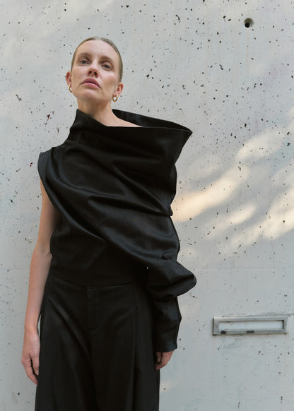 One-shoulder black asymmetric top for women with sculptural draping, statement folds, and minimalist design